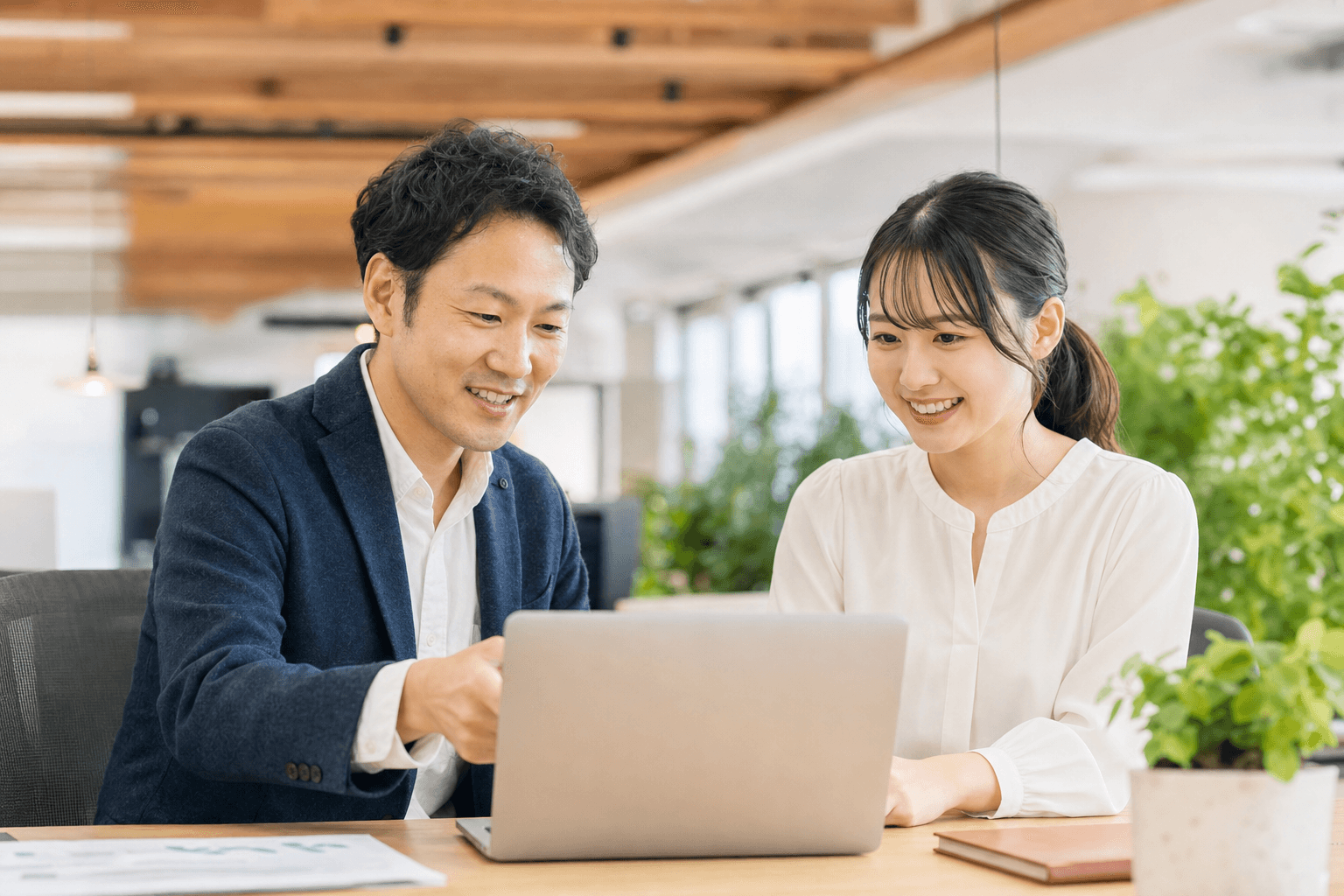 AI推進室の取り組みについて話し合う2人のビジネスパーソン