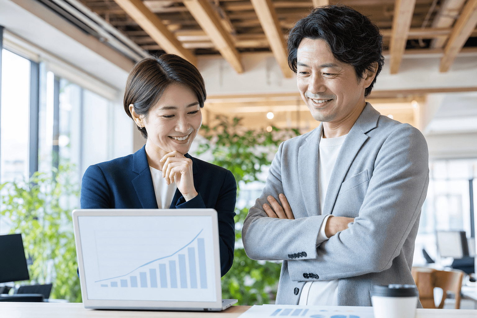 成果の出た指標を確認しながら話し合う2人のビジネスパーソン